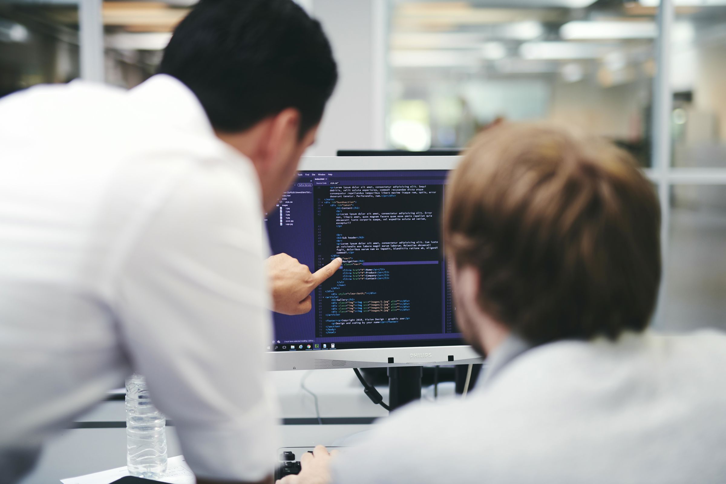 En elev på uddannelsen til webudvikler undervises i kodning på computeren.