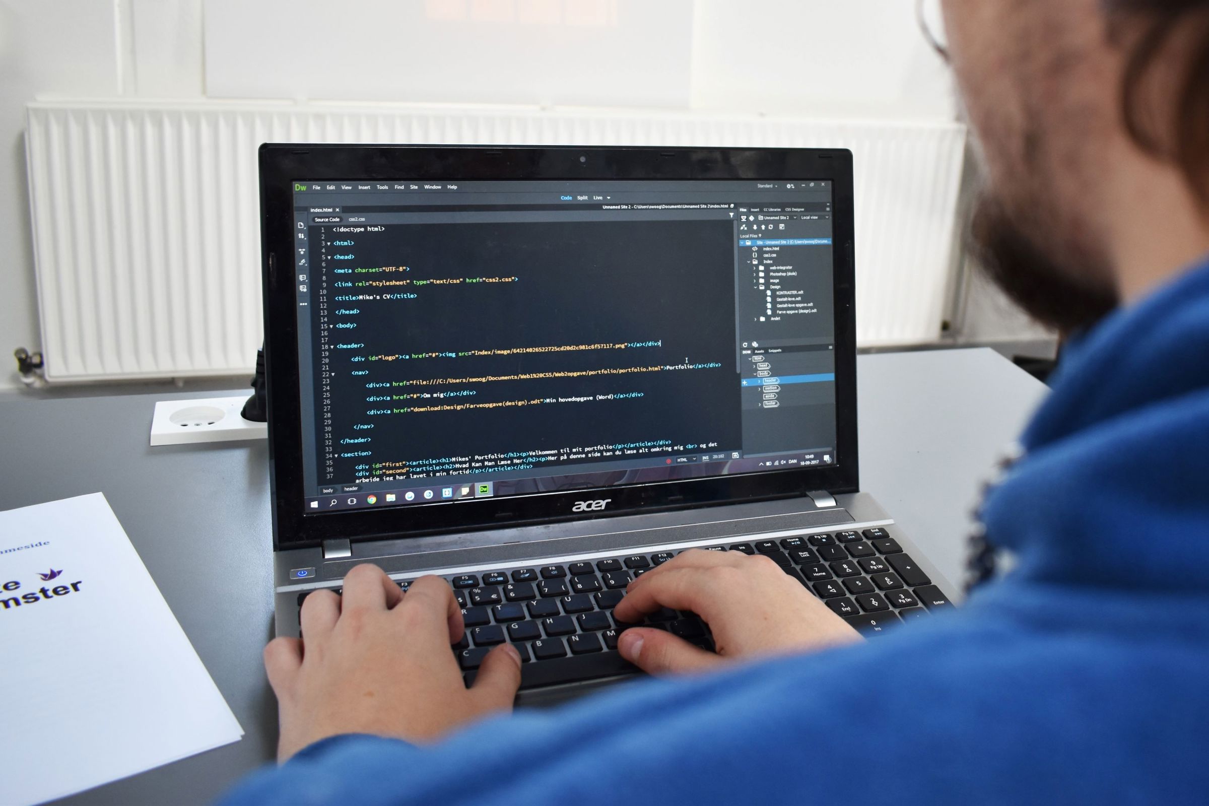 En elev på Hansenbergs webudvikleruddannelse sidder og skriver koder på en labtop.