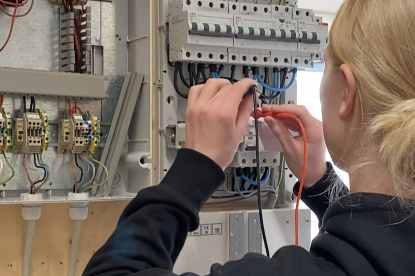 En elev på elektrikeruddannelsen måler efter, om ledningerne er tilsluttet korrekt på eltavlen.