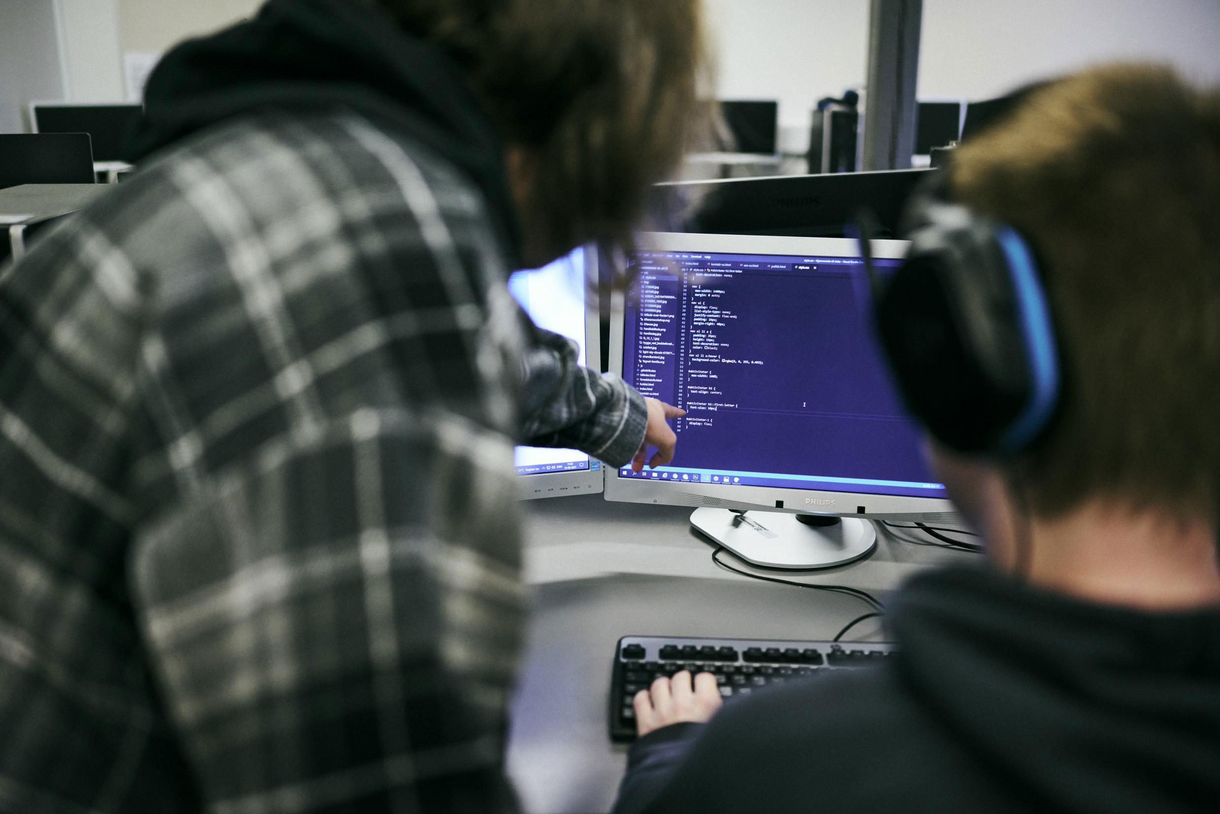 Eleverne på uddannelsen til webudvikler vurderer de indtastede koder på computerskærmen.