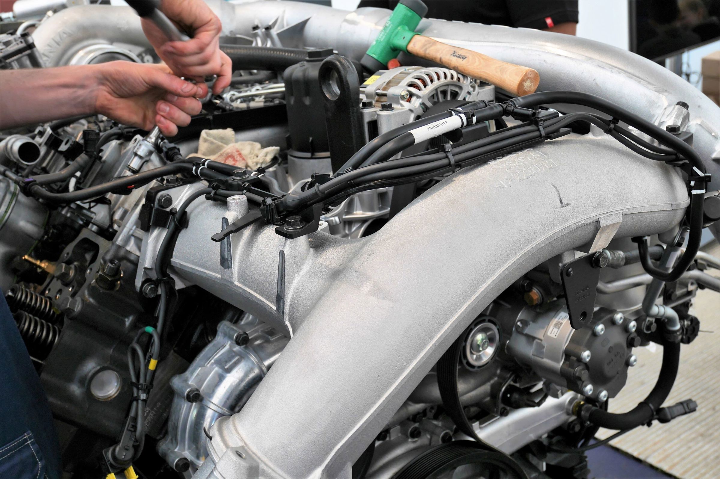 En elev på uddannelsen til lastvognsmekaniker reparerer en lastvognsmotor.